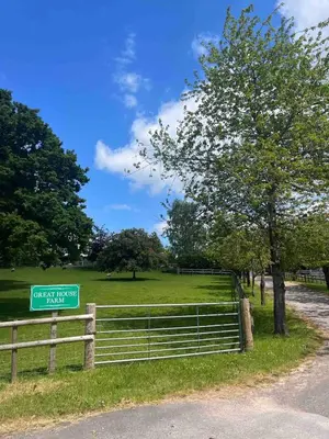 a green sign on a fence next to a field at Ty Cwtch Cabin - secluded woodland cabin & covered hot tub in Moffat