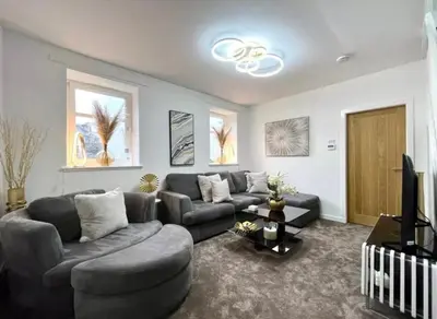 a living room with a couch and a tv at Cosy Hideaway in Stirling