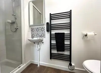 a bathroom with a shower and a sink and a mirror at Cosy Hideaway in Stirling