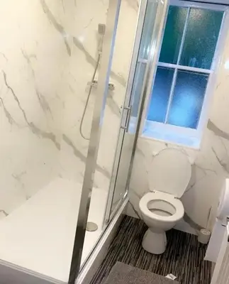 a bathroom with a toilet and a glass shower at The Woodside in Cowdenbeath