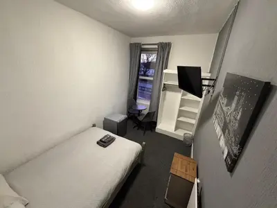 a small bedroom with a bed and a window at The Woodside in Cowdenbeath