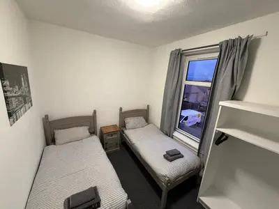 two beds in a room with a window at The Woodside in Cowdenbeath