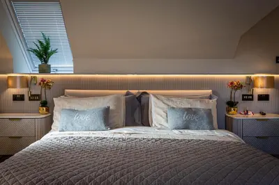 a bedroom with a large bed with two pillows at The Shore House in Lamlash
