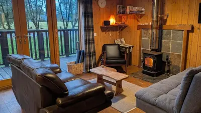 a living room with a couch and a fireplace at Bracken Lodge in Dalavich