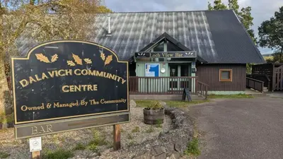 a sign in front of a building with a bar at Bracken Lodge in Dalavich