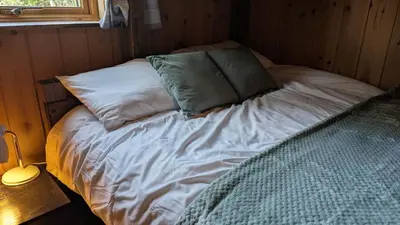 a bed with two pillows on it in a room at Bracken Lodge in Dalavich