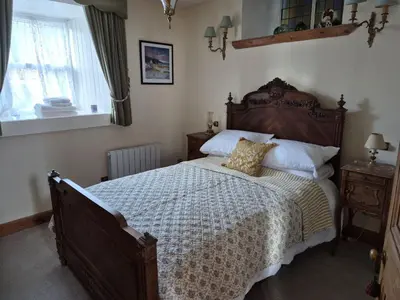 a bedroom with a large bed and a window at Kilfinichen Church in Kilfinchen