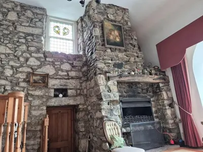 a stone wall with a fireplace in a room at Kilfinichen Church in Kilfinchen