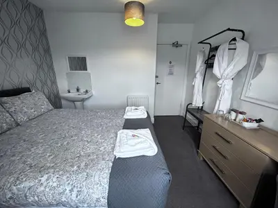 a bedroom with a bed and a dresser and a sink at Glendale Guesthouse in Oban