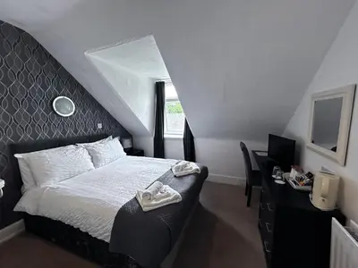 a bedroom with a bed and a desk with a computer at Glendale Guesthouse in Oban