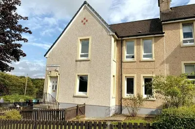 a house with a fence in front of it at Glasgow 2 Bedroom Apartment Access To City Centre in Gartcosh