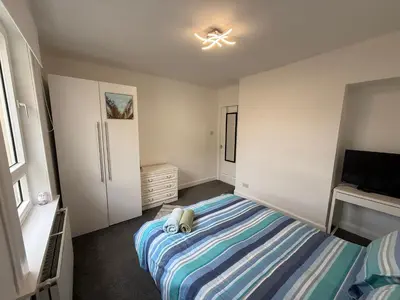 a small bedroom with a bed and a tv at Glasgow 2 Bedroom Apartment Access To City Centre in Gartcosh