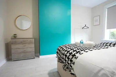 a bedroom with a bed and a blue wall at Stobhill Apartment in Glasgow