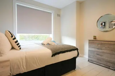 a bedroom with a bed with a window and a dresser at Stobhill Apartment in Glasgow