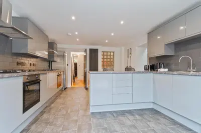 a large kitchen with white cabinets and appliances at Faulkner Luxury Suites in Moffat