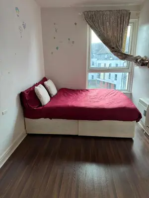 a bedroom with a bed with a red blanket and a window at Charming Edinburgh Apartment with Electric Heating Free WiFi in Edinburgh