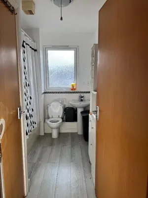 a bathroom with a toilet and a sink and a window at Charming Edinburgh Apartment with Electric Heating Free WiFi in Edinburgh