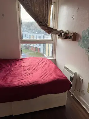 a bedroom with a red bed and a window at Charming Edinburgh Apartment with Electric Heating Free WiFi in Edinburgh