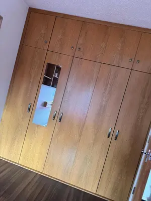 a close up of a wooden closet with drawers at Charming Edinburgh Apartment with Electric Heating Free WiFi in Edinburgh