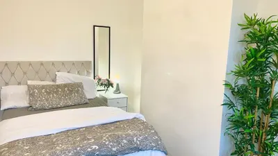 a bedroom with a bed with a mirror and plants at Luxury Spacious Double Room, Mill Hill, London NW7 3BD in Moffat