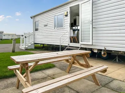 a wooden bench sitting next to a trailer at Coastal Bay View in Ayr