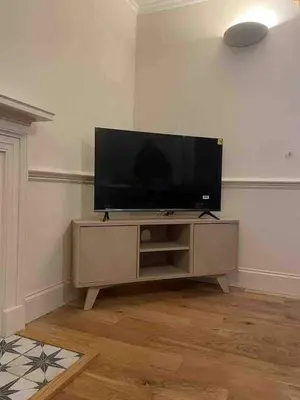 a living room with a flat screen tv on a entertainment center at Linlithgow cottage close to Edinburgh in Linlithgow