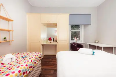 a bedroom with two beds and a window at Stylish and Unique Apartment by the Meadows 8 in Edinburgh