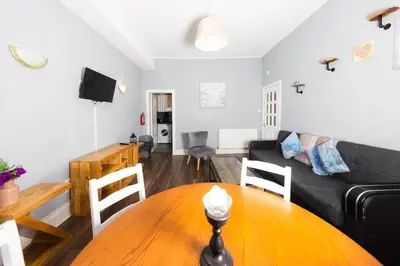 a living room with a table and a couch at Stylish and Unique Apartment by the Meadows 8 in Edinburgh