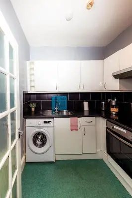a kitchen with a washer and a washing machine at Stylish and Unique Apartment by the Meadows 8 in Edinburgh
