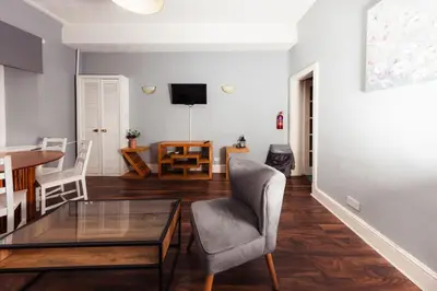 a living room with a table and a chair at Stylish and Unique Apartment by the Meadows 8 in Edinburgh