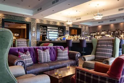 a lobby with couches and a bar in the background at 2 Bedroom detached lodge overlooking Loch Lomond in Balloch