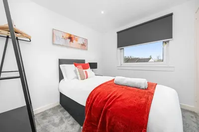 a bedroom with a bed and a window at The Elphin Escape in East Kilbride