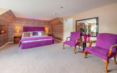 a bedroom with a purple bed and two purple chairs at The Clachan Hotel, Lochearnhead in Lochearnhead