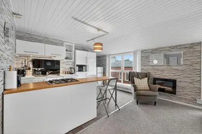 a kitchen with a counter and chairs in a room at Coastal Charm: Modern Retreat by Seafront in Largs