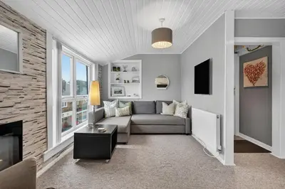 a living room with a couch and a fireplace at Coastal Charm: Modern Retreat by Seafront in Largs