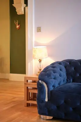 a blue couch in a living room with a lamp at Bruce on the Row-Historic Elegance near Edinburgh by Urban Haggis Stays in Dunfermline