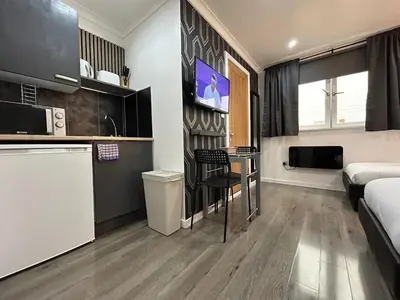 a room with a bed and a kitchen with a table at Glasgow Studio in Glasgow