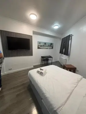a bedroom with a bed and a flat screen tv at Glasgow Studio in Glasgow