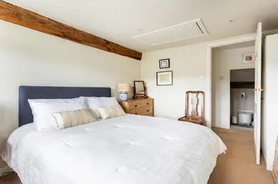a bedroom with a large white bed with a blue headboard at Woodlea Cottage in Moffat