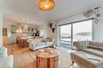 a living room with a couch and a table and a kitchen at 3 Bed in Kirkcolm oc-b34009 in Kirkcolm