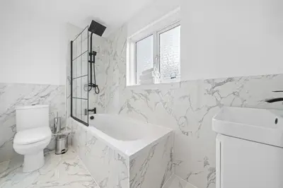 a white bathroom with a sink and a toilet at Linden House in Hamilton