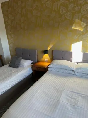 two beds sitting next to each other in a room at west park hotel PVT ltd in Clydebank