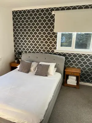 a bedroom with a bed with white sheets and a window at west park hotel PVT ltd in Clydebank
