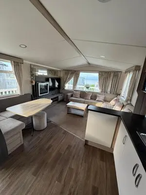 a living room with a couch and a table at Luxury Seafront 3 Bedroom Caravan in Minishant
