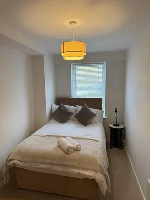a bedroom with a large bed with a yellow light at Modern&Stylish city centre apartment with parking in Glasgow