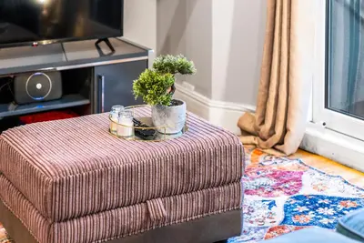 a plant sitting on a ottoman in a living room at Charming Village Escape 3-Bed near Loch Lomond in Drymen