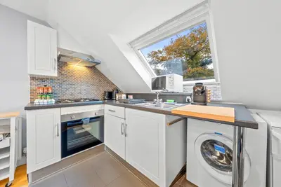 a kitchen with a washing machine and a window at Charming Village Escape 3-Bed near Loch Lomond in Drymen