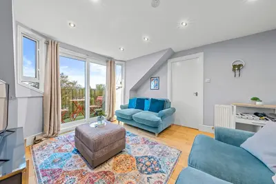 a living room with blue furniture and a large window at Charming Village Escape 3-Bed near Loch Lomond in Drymen