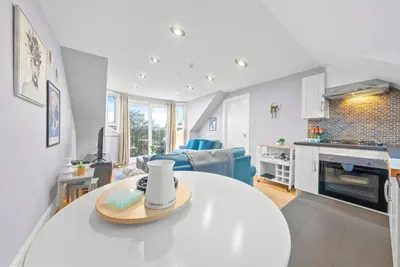 a kitchen and living room with a table in a room at Charming Village Escape 3-Bed near Loch Lomond in Drymen