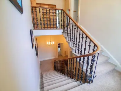 a staircase with a wooden rail and white stairs at Hillside House in Dunfermline